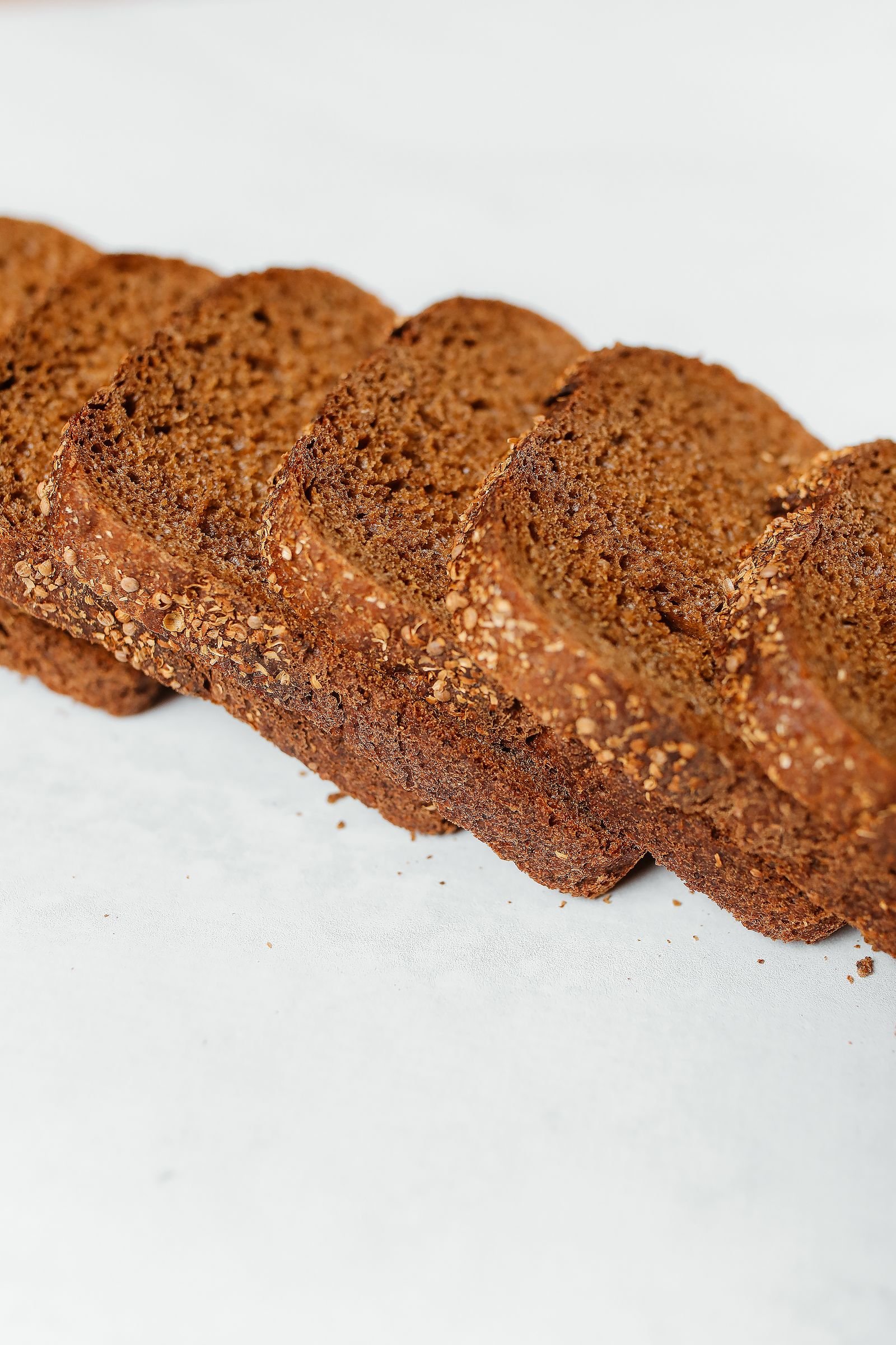 Fanned slices of dense dark rye bread with a seeded crust